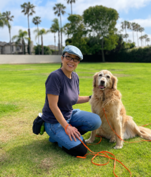 Nicole Narita, sitting next to Goldie, a senior Golden Retriever, at Bailey Park in Huntington Beach, California.